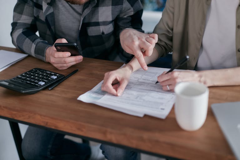 A Couple Sitting at the Table looking at electricity, water and gas bills to pay